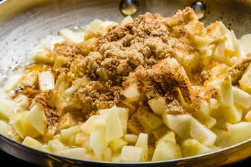 Fresh apples cut up being cooked into sauce