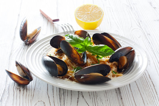 Pasta with mussels, tomato sauce and parmesan closeup
