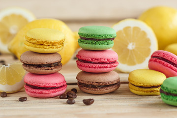Green, pink, yellow and brown french macarons with lemon and coffee beans