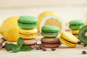 Green and yellow french macarons with kiwi, lemon and mint decorations