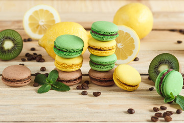 Green and yellow french macarons with kiwi, lemon and mint decorations