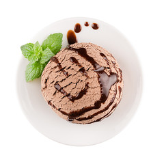 Ice cream brown scoop on plate decorated mint leaves, chocolate sauce, top view, isolated on white background.