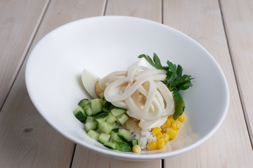 Salad with squid, corn, rice and cucumber