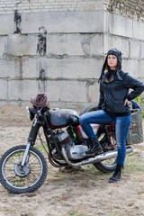 Obraz na płótnie Canvas A post apocalyptic woman near motorcycle near the destroyed building