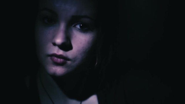 Face of a beautiful girl in the dark close-up
