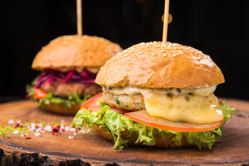 tasty burgers on wooden board