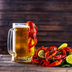 Mug of beer and boiled crawfish on a wooden table
