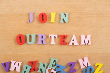 JOIN OUR TEAM word on wooden background composed from colorful abc alphabet block wooden letters, copy space for ad text. Learning english concept.