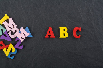 ABC word on black board background composed from colorful abc alphabet block wooden letters, copy space for ad text. Learning english concept.