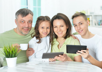 family sitting at table with gadgets