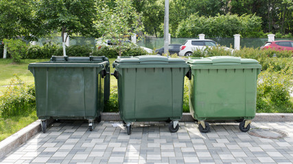 Opened green plastic recycling container at the sunny city street