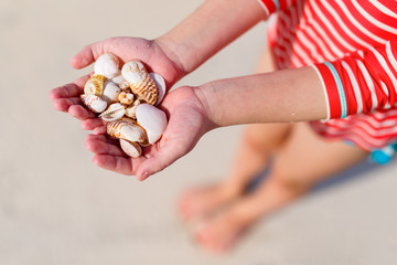 Obraz premium Girl holding sea shells