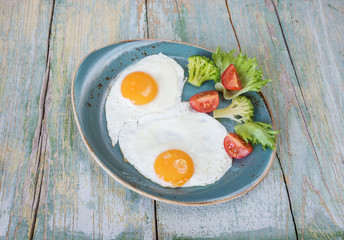 Two fried eggs and vegetables