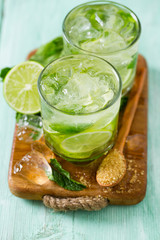 Mojito and ingredients on turquoise wooden surface