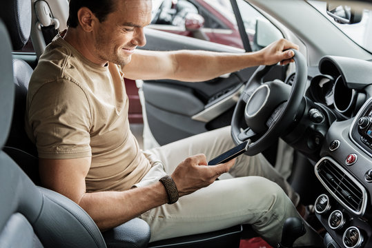 Outgoing Male Watching At Phone In Car