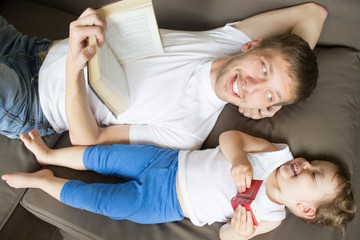 Dad is reading a book with a child. Young father. Father's Day