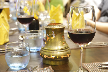 grape wine in the wine glass for dinner drink and water with brass lantern on the table in business party celebration and success at restaurant on warm white