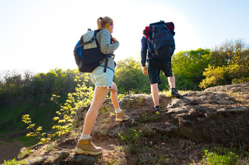 Couple backpackers hiking in the forest during summer. Travel, hiking, backpacking, tourism and people concept