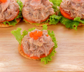Tuna salad on  biscuit and vegetable isolated  on  wood