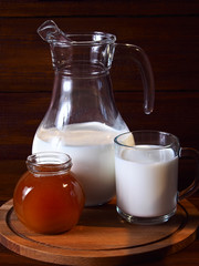 Still life with jug of milk on a wooden background