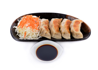 Gyoza with sauce in black plate isolated on white background