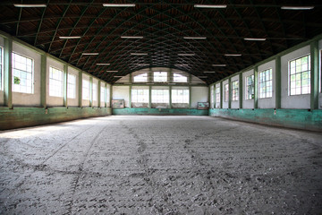 Panoramic view of an old fashioned riding hall with sandy covering without people