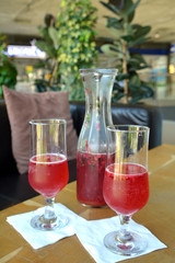 Summer lemonade with raspberry and leaves mint in a glass jug