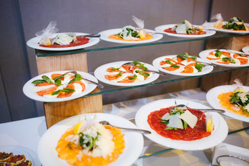 Cold cuts in white plate on wooden board