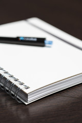 White notebook with a pen on an office close up