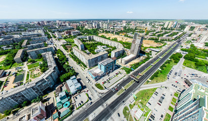 Fototapeta na wymiar Aerial city view with crossroads and roads, houses, buildings, parks and parking lots, bridges. Helicopter drone shot. Wide Panoramic image.