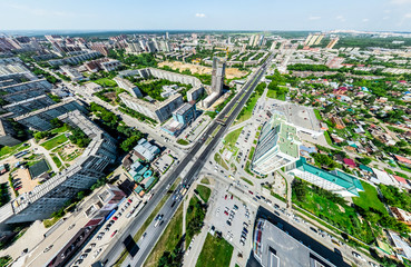 Aerial city view with crossroads and roads, houses, buildings, parks and parking lots, bridges. Helicopter drone shot. Wide Panoramic image.