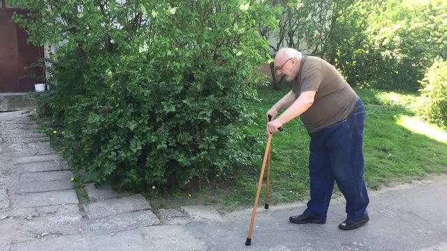 Elderly man walking with wooden walking canes