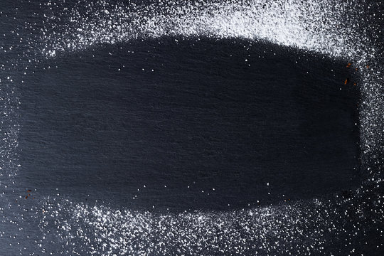 Frame made of powdered sugar on a black slate plate.