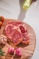 Raw beef on a cutting board  with spices and ingredients for cooking.