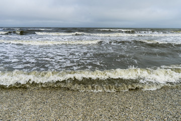 Landscape with sea view, waves and sea shells, clouds, photographed in Gura Portiţei, Romania, in cloudy spring day