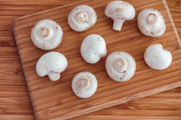 Champignon mushrooms on a wooden cutting board