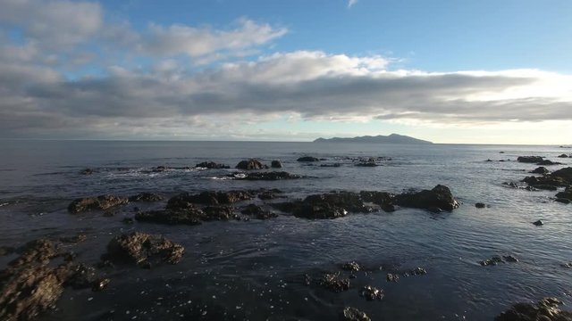 Aerial view of rocky shore and Kapiti Island in the distance, New Zealand