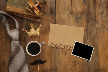 old books, glitter crown, necktie and cup of coffee. Father's day concept
