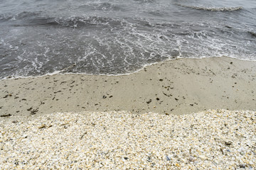 Landscape with sea view, waves and sea shells, clouds, photographed in Gura Portiţei, Romania, in cloudy spring day