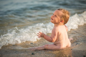 Fototapeta na wymiar Little child girl playing on sea beach. Summer vacation
