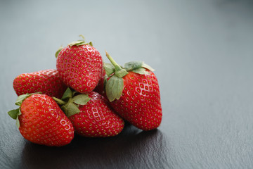 ripe organic strawberries on slate background, closeup