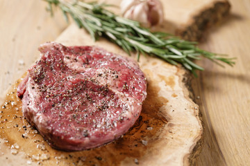 raw rib eye steak on board closeup, shallow focus