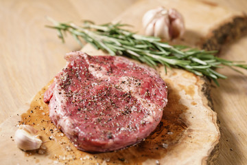 raw rib eye steak on board closeup, shallow focus