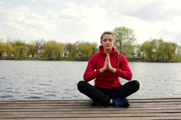 Fototapeta na wymiar Meditating serene woman in lotus on pier, river, healthy lifestyle, yoga