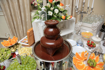 Płynna czekolada, owoce i słodkie ciasta na stole urodzinowym w restauracji. - obrazy, fototapety, plakaty