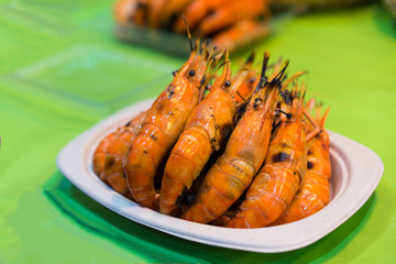 Several burnt shrimp are placed in a bowl on a kitchen table.