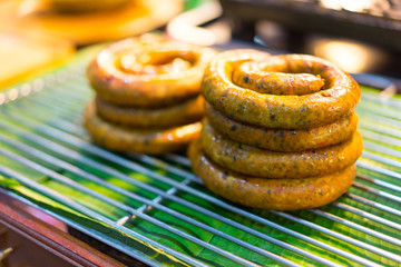 Thai sausage being roasted on a food center.
