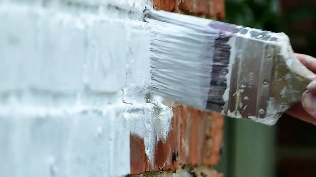 Painting brick house close up slow motion