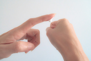 Naklejka premium Close-Up Woman Hand Applying Moisturizing cream on White Background