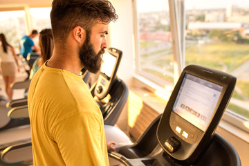 man at the gym exercise on bike and surfing on Internet